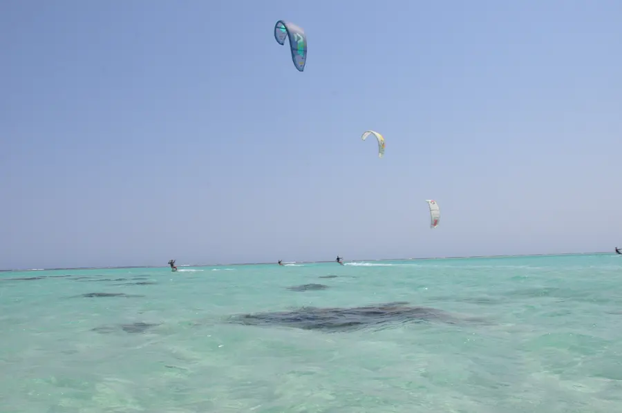 Kite high above the turquoise lagoon with a rider far below