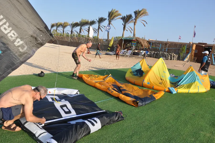 Kites and equipment laid out on the grass at the KiteMood base in Marsa Alam