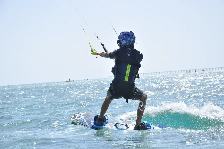 Kitesurfer riding across sparkling blue water in Marsa Alam